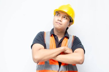 Asyalı kendine güvenen genç bir inşaat işçisi ya da mühendisinin portresi beyaz bir arkaplanda parlak bir gelecek görmek için ayakta duruyor. Parlak gelecek iş ve işçi konsepti.