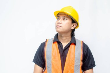 Asyalı kendine güvenen genç bir inşaat işçisi ya da mühendisinin portresi beyaz bir arkaplanda parlak bir gelecek görmek için ayakta duruyor. Parlak gelecek iş ve işçi konsepti.