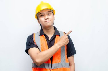 Siyah gömlekli ve sarı kasklı Asyalı mutlu inşaat işçisi reklamları gösteriyor.