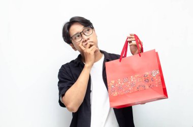 Kırmızı Batik desenli alışveriş çantası tutan çekici ve şık Asyalı genç adam.