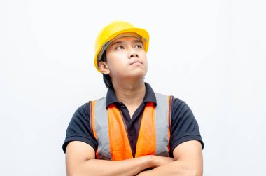 Asyalı kendine güvenen genç bir inşaat işçisi ya da mühendisinin portresi beyaz bir arkaplanda parlak bir gelecek görmek için ayakta duruyor. Parlak gelecek iş ve işçi konsepti.