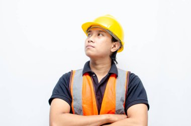 Asyalı kendine güvenen genç bir inşaat işçisi ya da mühendisinin portresi beyaz bir arkaplanda parlak bir gelecek görmek için ayakta duruyor. Parlak gelecek iş ve işçi konsepti.