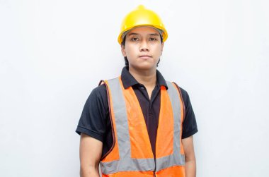 Asyalı kendine güvenen genç bir inşaat işçisi ya da mühendisinin portresi beyaz bir arkaplanda parlak bir gelecek görmek için ayakta duruyor. Parlak gelecek iş ve işçi konsepti.