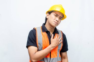 Asyalı Erkek İnşaat İşçisi Hardhat ve Turuncu Yelek Üzgün görünüyor. Aşırı çalışma kavramını vurguladım. İşçi Sigortası Kavramı.