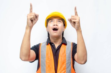 Siyah gömlekli ve sarı kasklı Asyalı mutlu inşaat işçisi reklamları gösteriyor.