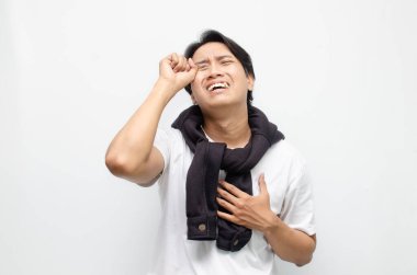 Genç Asyalı bir adam üzgün bir ifadeyle ağlıyor, derin duyguları ve kırılganlığı yakalıyor. Duygusal ve zihinsel sağlık temaları için ideal.