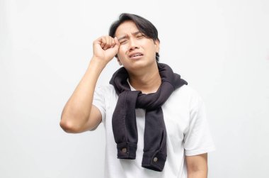 Genç Asyalı bir adam üzgün bir ifadeyle ağlıyor, derin duyguları ve kırılganlığı yakalıyor. Duygusal ve zihinsel sağlık temaları için ideal.