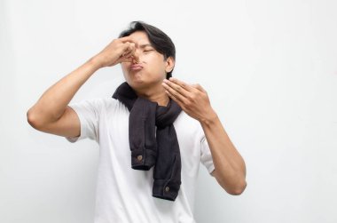 İğrenç bir suratı olan genç bir Asyalı, kötü bir kokuya tepki veriyor. Kötü koku, hava kalitesi veya kişisel hijyen kavramları için mükemmel.