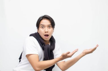 Günlük kıyafetli genç Asyalı adam fotokopi alanını işaret ediyor. Reklam ve tanıtım şablonları için mükemmel. Sergi ürünleri veya iletiler için ideal