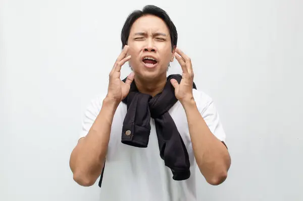 Genç Asyalı adam öksürüyor ve grip belirtileri gösteriyor. Ateşli bir bakışla. Sağlık, hastalık ve mevsimsel grip farkındalığı kavramları için ideal