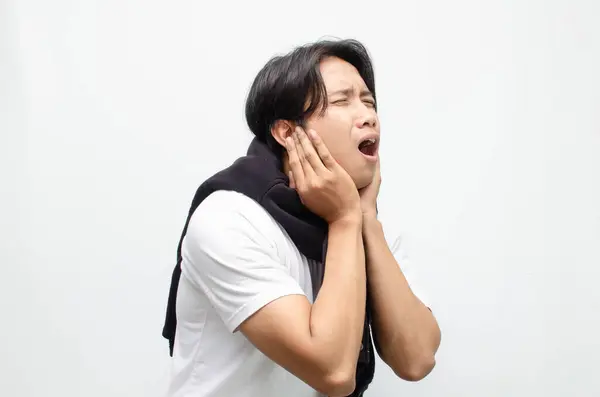 Kızgın genç Asyalı adam kulaklarını ellerle kapatıyor, gürültüden ve sıkıntıdan şikayetçi olduğunu söylüyor. Gürültü kirliliği, tahriş ve duygusal tepki kavramları için mükemmel.