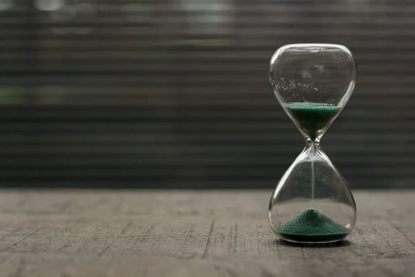 Mavi yeşil kumlu bir kum saatine yakın çekim. Bulanık arkaplan. 