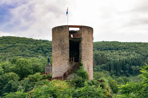 Esch Sur Sure, Lüksemburg 'da küçük bir kule. Önünde bir sürü yeşil ağaç var..