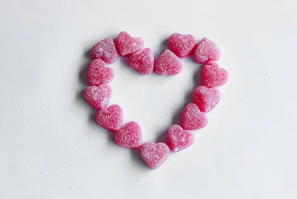 Pink heart made out hearts candies on a white background. Valentine's day. Love