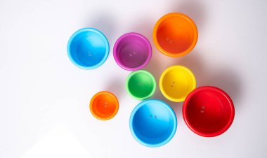 Beyaz arkaplan üzerine renkli plastik bardaklar istifleme. Denge konsepti