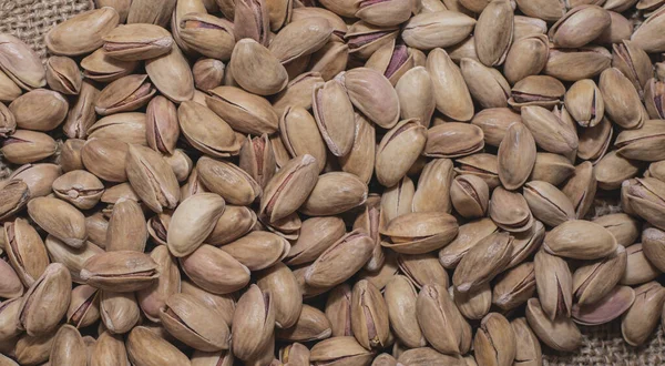 Çuval üstünde fıstıklar. Yüksek proteinli sağlıklı yiyecekler. Beslenme düzeni. Yakın plan. düz yat