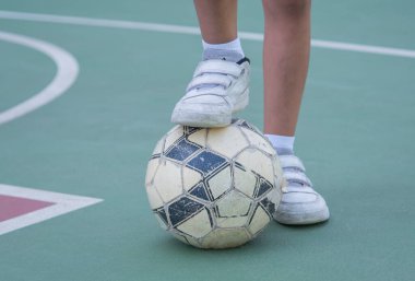 Çocuk bir futbol topu oynuyor. Okul bahçesinde top oynayan bir çocuk. Çocuk sporları. Sağlık