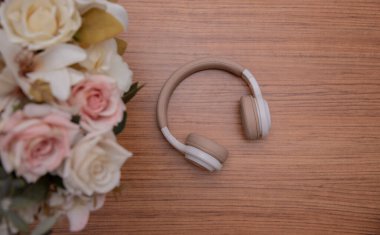 Tahta bir yüzeyde kablosuz kulaklıklar. Metin için boşluk. Düz yatıyordu. en üstteki görünüm