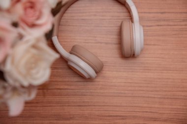 Tahta bir yüzeyde kablosuz kulaklıklar. Metin için boşluk. Düz yatıyordu. en üstteki görünüm