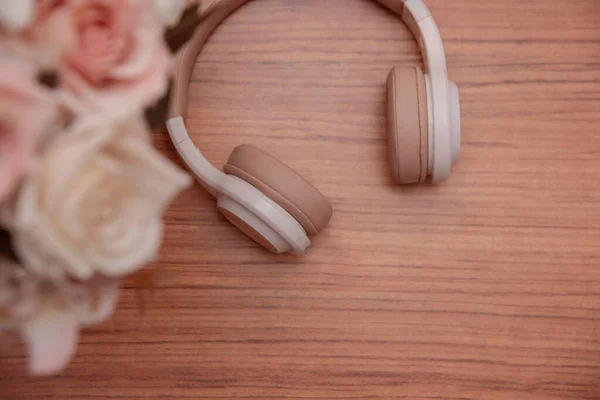 Tahta bir yüzeyde kablosuz kulaklıklar. Metin için boşluk. Düz yatıyordu. en üstteki görünüm