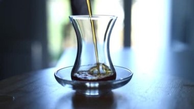 Türk çayını modern bir Türk bardağına doldurmak, yakın çekim, gerçek zamanlı. 
