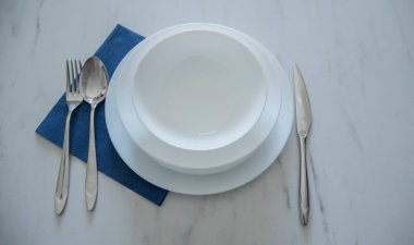 Beyaz mutfak masasının üzerinde boş beyaz bir tabak vardı.