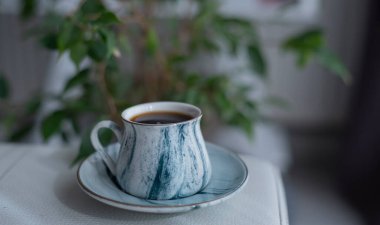 Beyaz yüzeyde bir fincan kahve. Sıcak kahve bardağına yakın çekim. Sıcak kahve içeceği konsepti.