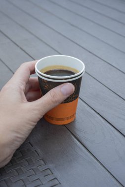 Kadınların elindeki kağıt kahve fincanları.