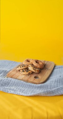 Sarı arka planda küçük tuzlu kurabiyeler. Geleneksel Türkçe simit. Kapat..