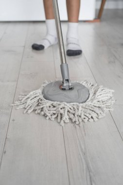 Modern beyaz paspaslı çocuk ahşabı temizliyor.