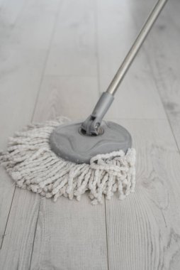 Modern beyaz paspaslı çocuk ahşabı temizliyor.