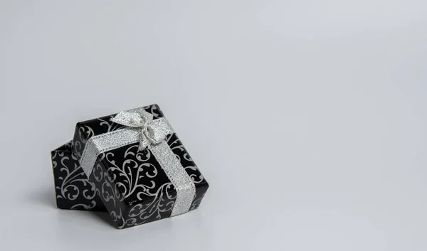 Beyaz arkaplanda siyah hediye kutusu izole.