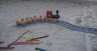 Oturma odasının zemininde çok renkli bir tren oyuncağı var.