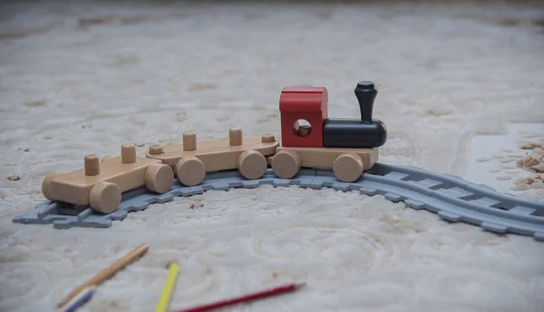 Oturma odasının zemininde çok renkli bir tren oyuncağı var.