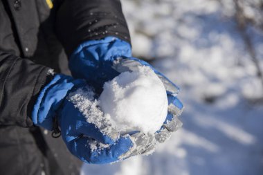 Kar topu çocuğun elinde.