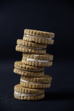 Siyah arka planda kremalı bisküvi. Güzel kavram.