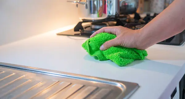 Yeşil bez mendilli kadın eli. Temizlik hizmeti konsepti..