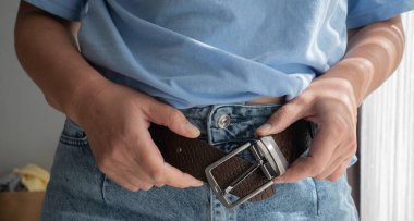 Kottaki deri kemeri çözen eller.