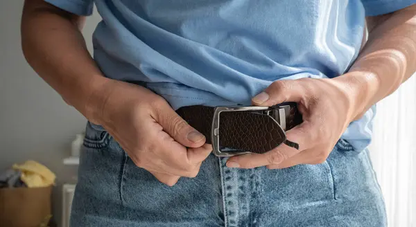 Kottaki deri kemeri çözen eller.