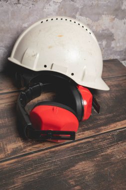 Red safety earphones and white helmet.construction site concept clipart