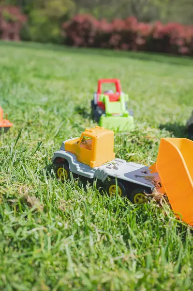 Güneşli bir günde çimlerin üzerinde oyuncak arabalar.