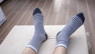 Erkek ayağında siyah çizgili gri çoraplar..