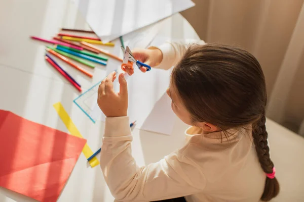 Энтузиазм Ребенка Комнате Столом Вырезает Ремесла Разноцветной Бумаги Ножницами Солнечном — стоковое фото