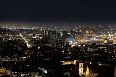 Napoli 'nin gece manzarası, yön merkezi ve aydınlık binalarla süslenmiş bir ufuk çizgisi.