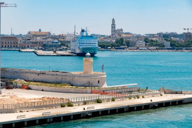 İtalya 'nın Bari limanının sakin bir manzarası, arka planda sakin turkuaz suları ve canlı marinayı gösteriyor. Sahne, bu hareketli sahil şehrinin özünü yakalıyor. Denizcilik cazibesini ve modern altyapısını vurguluyor.