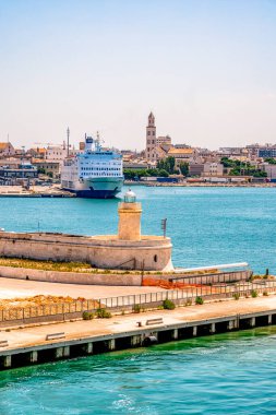 İtalya 'nın Bari limanının sakin bir manzarası, arka planda sakin turkuaz suları ve canlı marinayı gösteriyor. Sahne, bu hareketli sahil şehrinin özünü yakalıyor. Denizcilik cazibesini ve modern altyapısını vurguluyor.
