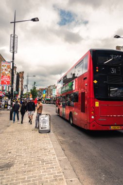 Londra 'daki Camden Market' in renkli sokaklarından canlı bir sahne, koleksiyon dükkanları, eşsiz sokak sanatı ve alternatif kültürüyle tanınıyor. Bu ikonik alan yaratıcılığın merkezidir. Yerlileri ve turistleri bu canlılığı keşfetmeleri için çeker.