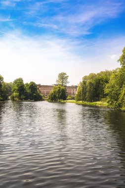 Londra 'daki St. Jamess Park Gölü' nün sakin bir manzarası. Yeşillik ve arka plandaki ikonik At Muhafızları binası çerçeveli. Huzurlu ortam, Londra 'nın en güzel kraliyet parklarından birindeki doğa ve mimarinin uyumunu yansıtıyor.