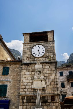Karadağ 'ın Kotor kentinin tarihi simgelerinden biri olan St. Tryphon' un çarpıcı katedrali, ikiz çan kuleleriyle yemyeşil dağlardan oluşan bir zemin üzerinde görkemli bir şekilde duruyor. Aşağıdaki hareketli kare bu tarihi ve ruhani yere canlılık katıyor.