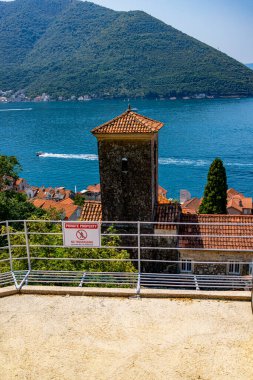 Karadağ 'ın Kotor Körfezi' ndeki iki ikonik adanın çarpıcı manzarası: Kayaların Leydisi ve Aziz George. Sakin mavi sular ve yemyeşil dağlarla çevrili bu resim Adriyatik kıyılarının dingin güzelliğini ve kültürel zenginliğini yansıtıyor.